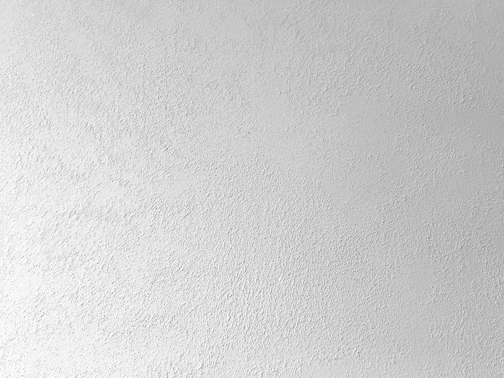 Матовая краска с мелким песком Oikos Biamax 3. Эффект песчаного вихря в один слой. Базовый цвет Bianco. Вид вблизи и под углом